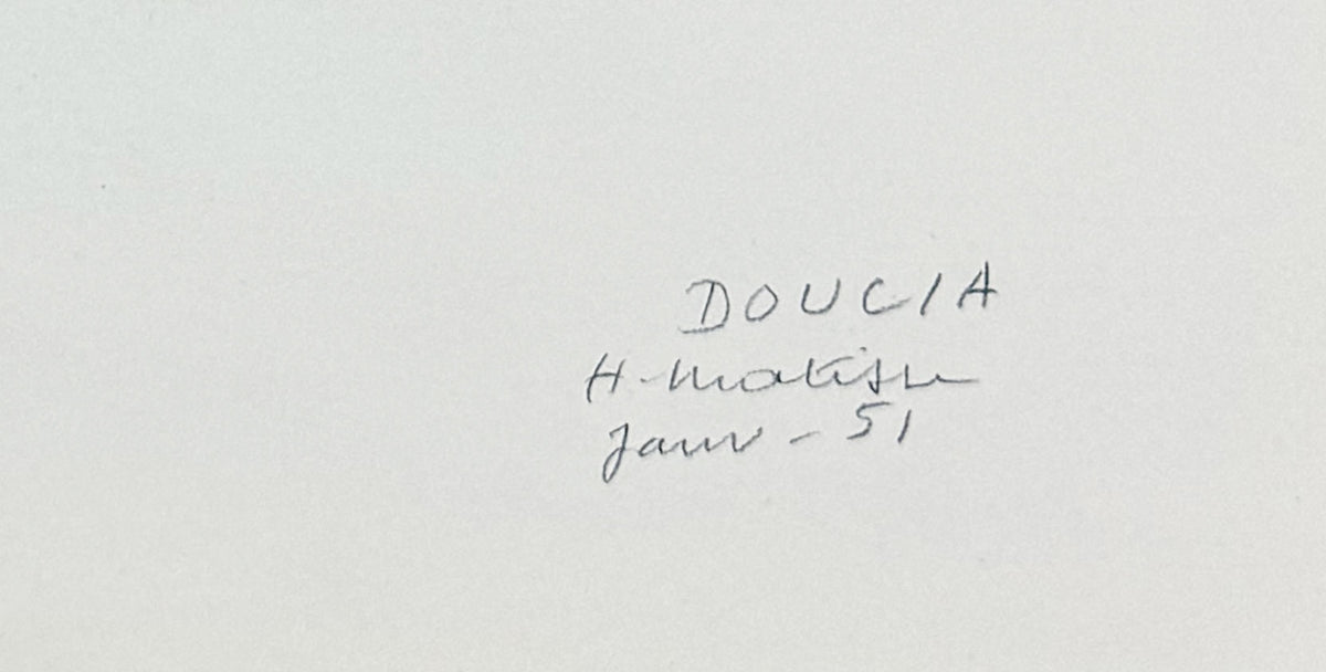 A close-up of a white surface with text in dark ink reading 'DOUCIA', 'H. Matisse'.