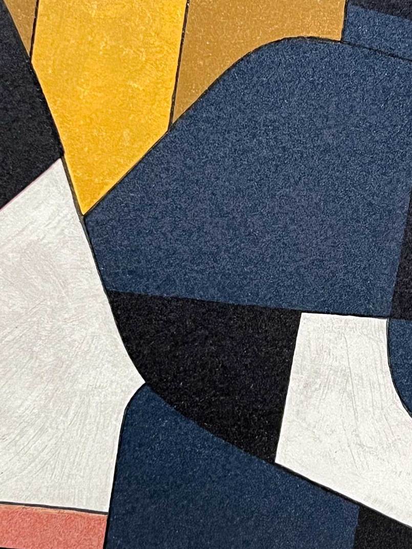 Abstract geometric wall art featuring bold blocks of navy blue, mustard yellow, white, black, and a small coral pink shape with visible woven texture.